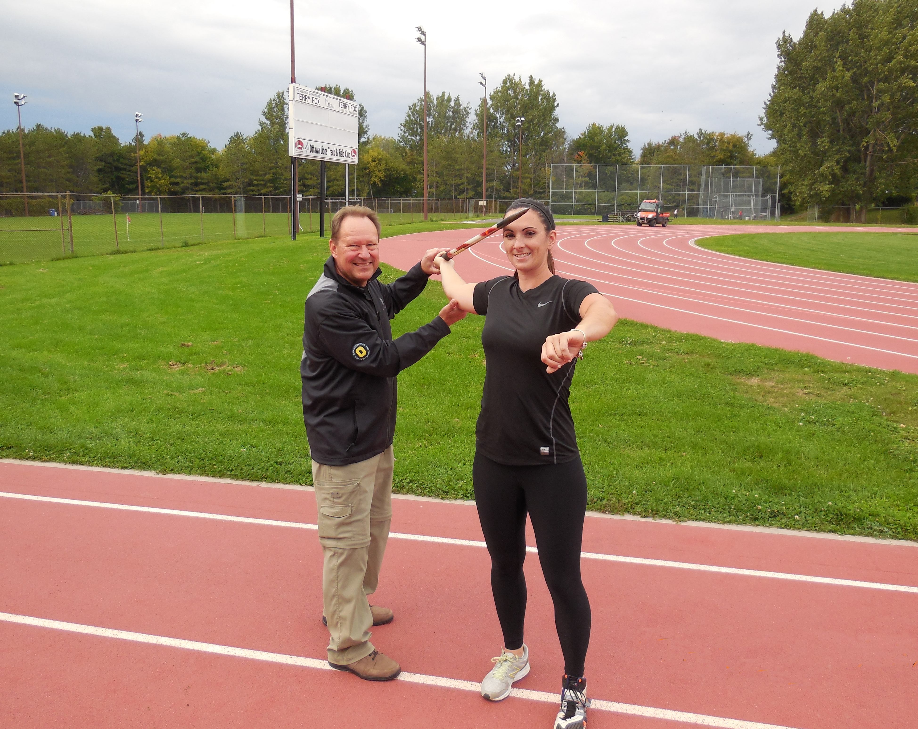 Bill Heikkila coaching an athlete on the track
