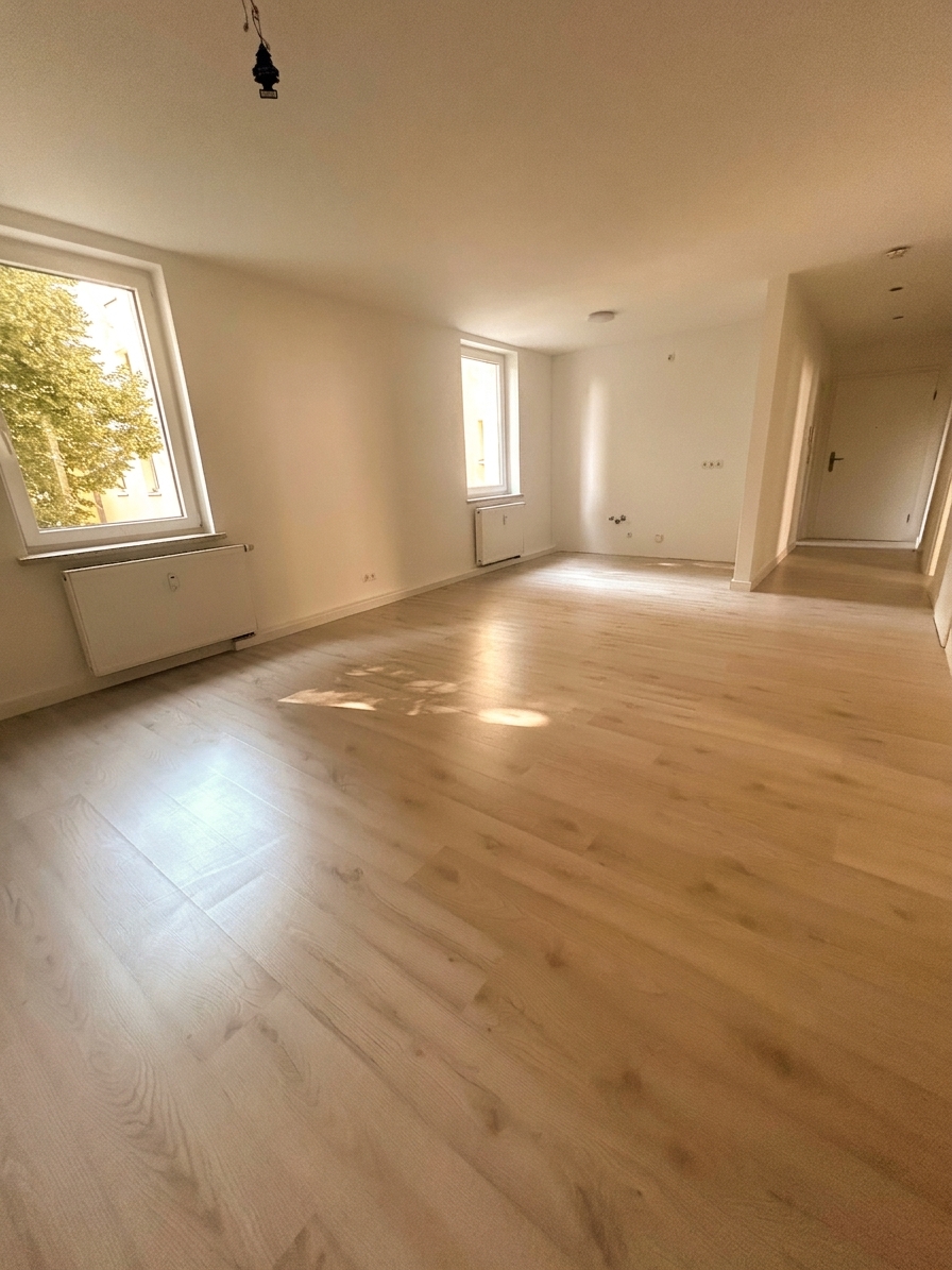 Helles, geräumiges Zimmer mit warmem Laminatboden und zwei großen Fenstern – 4-Zimmer-Wohnung in Dessau-Roßlau