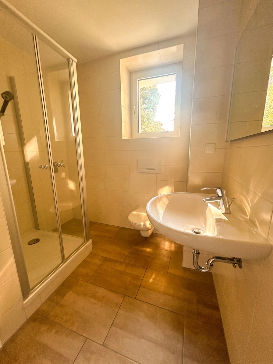 Helles Badezimmer mit Glasdusche, WC und Waschtisch mit Spiegel – 4-Zimmer-Wohnung in Dessau-Roßlau