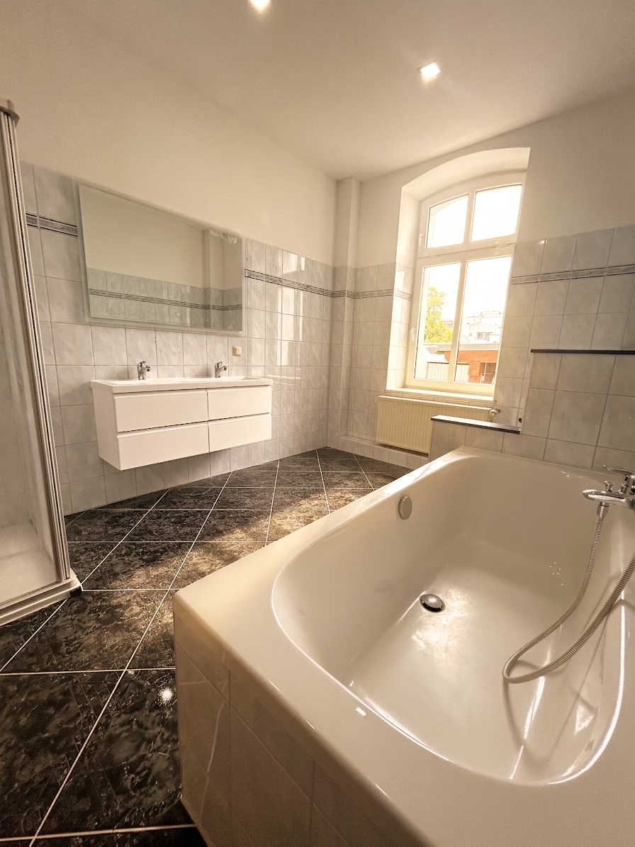 Großes Badezimmer mit Badewanne, Doppelwaschtisch, großem Spiegel und Bogenfenster – 3-Zimmer-Wohnung in Dessau-Roßlau