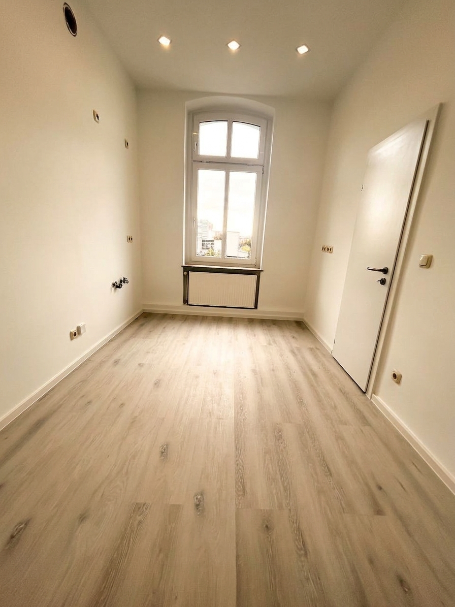 Helles Zimmer mit Bogenfenster, Einbauspots und hellem Laminatboden – 4-Zimmer-Wohnung in Dessau-Roßlau