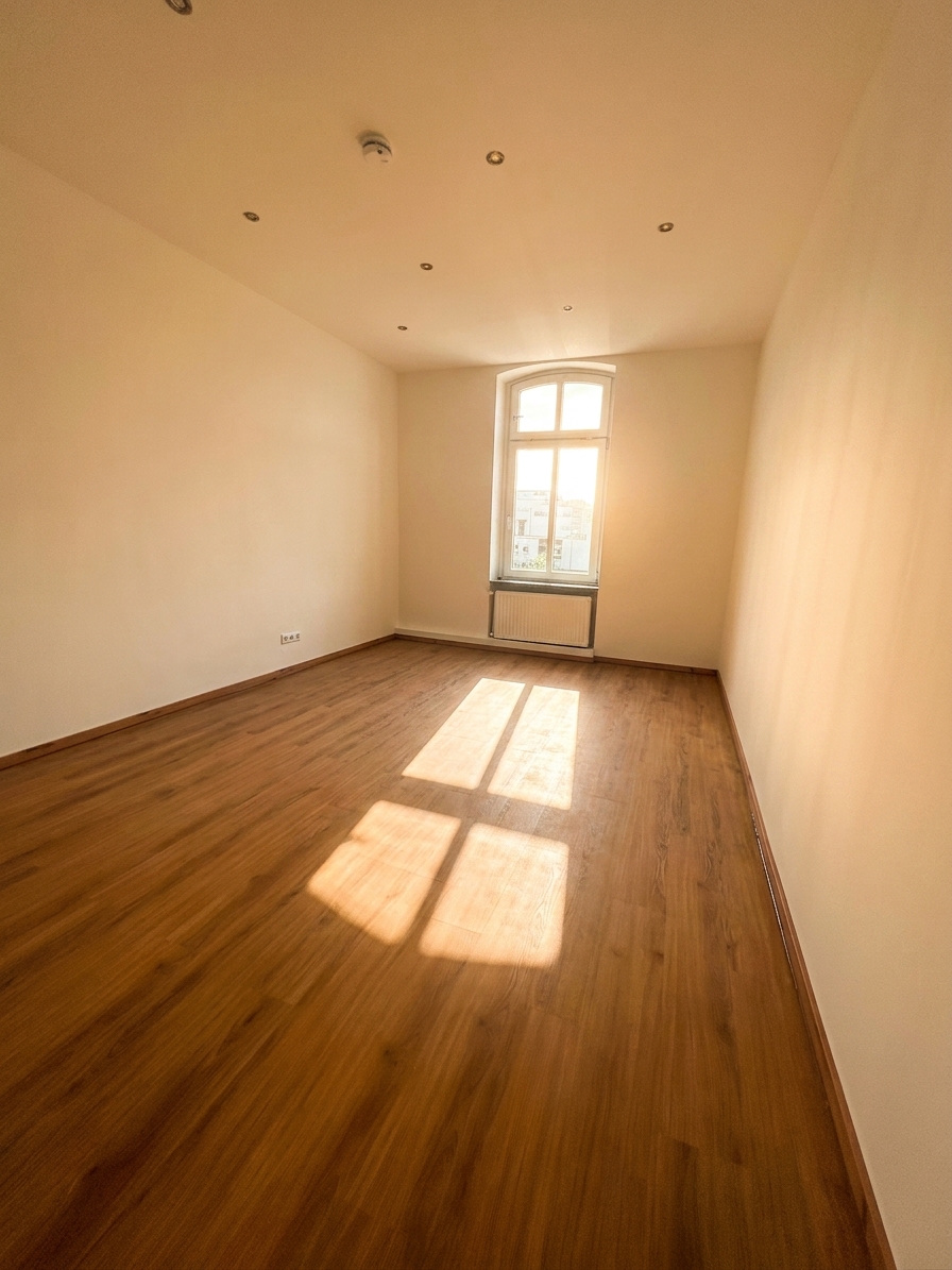 Helles Schlafzimmer mit warmem Holzboden, Einbauspots und Bogenfenster – 3-Zimmer-Wohnung in Dessau-Roßlau