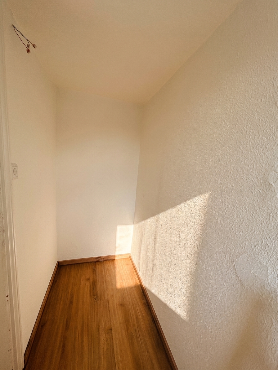 Heller Abstellraum mit warmem Holzboden und weißen Wänden – 3-Zimmer-Wohnung in Dessau-Roßlau