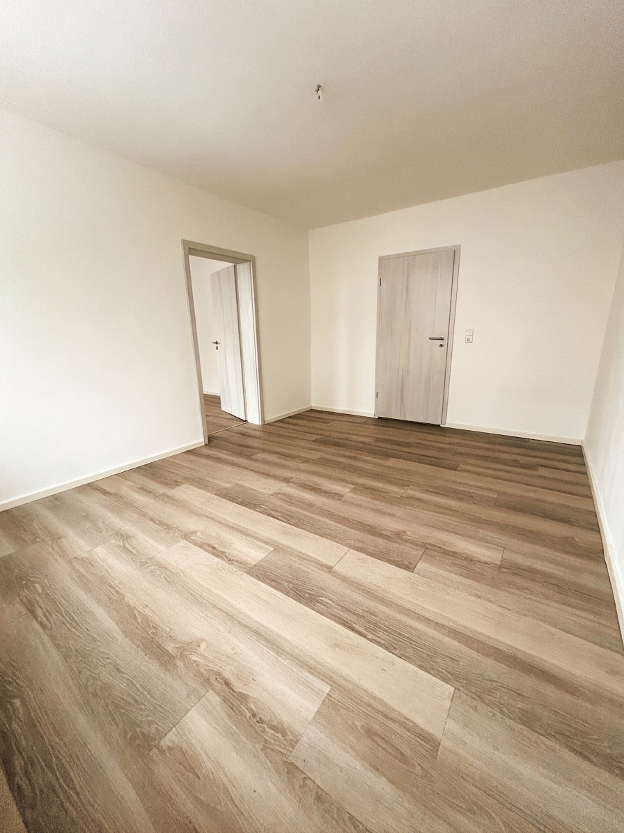 Drittes helles Zimmer mit warmem Laminatboden, Durchgang und Sonnenlicht – 3-Zimmer-Wohnung in Schorfheide
