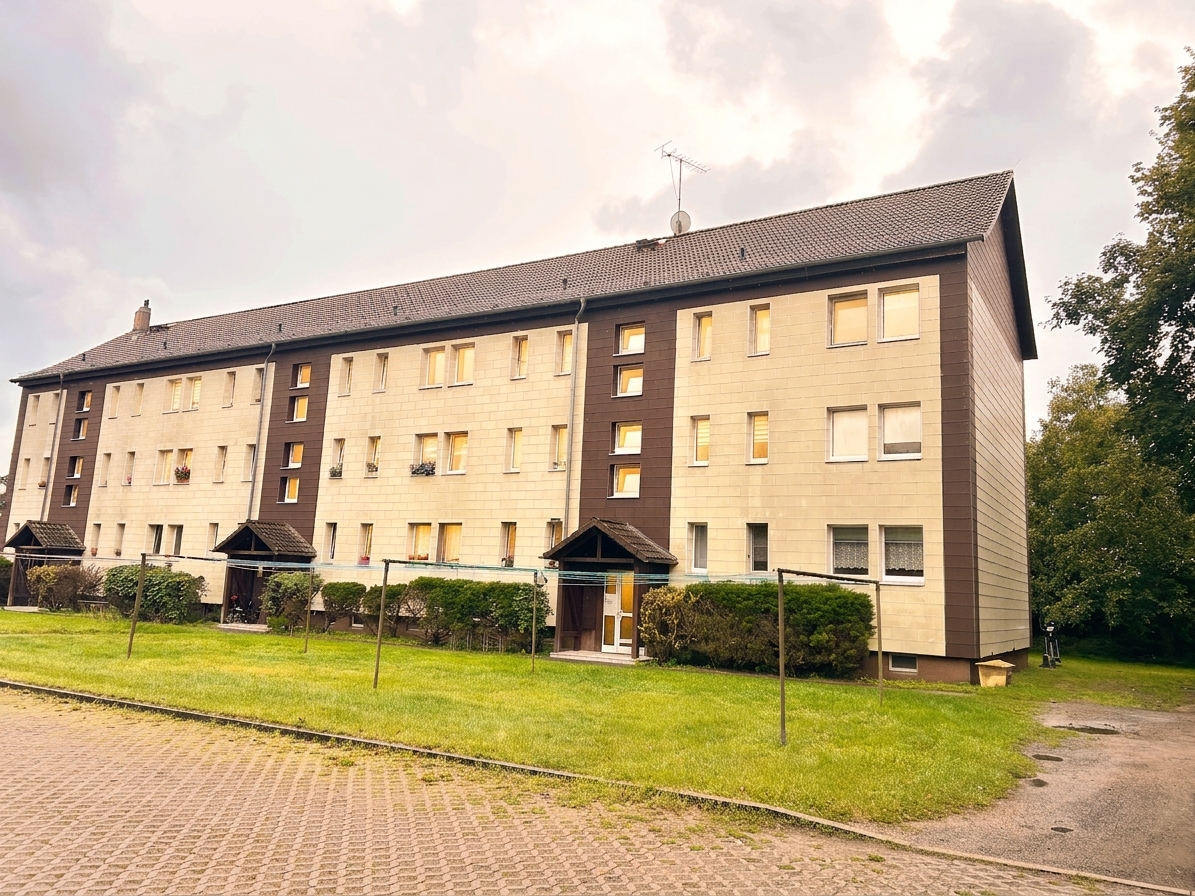 Außenansicht des Mehrfamilienhauses in Schorfheide mit gepflegtem Rasen und brauner Fassade
