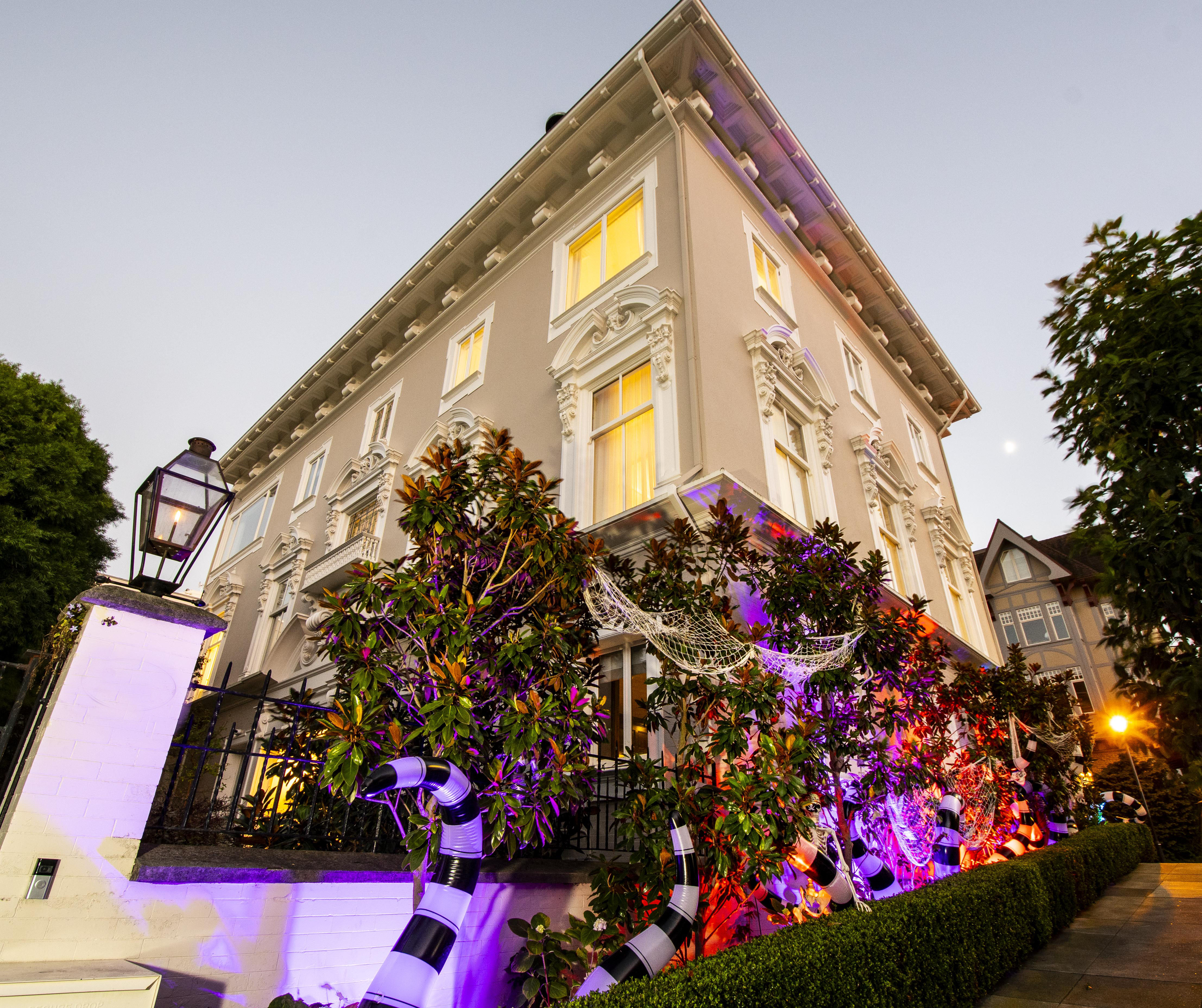 Halloween-decorated Victorian house exterior at night
