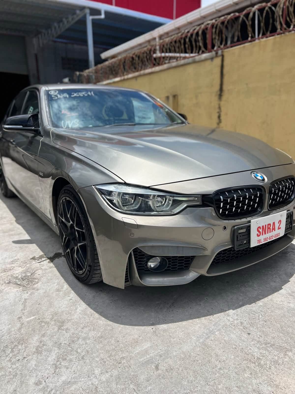 2016 BMW 318 bronze — three-quarter front view showing M-Sport body kit and black alloy wheels