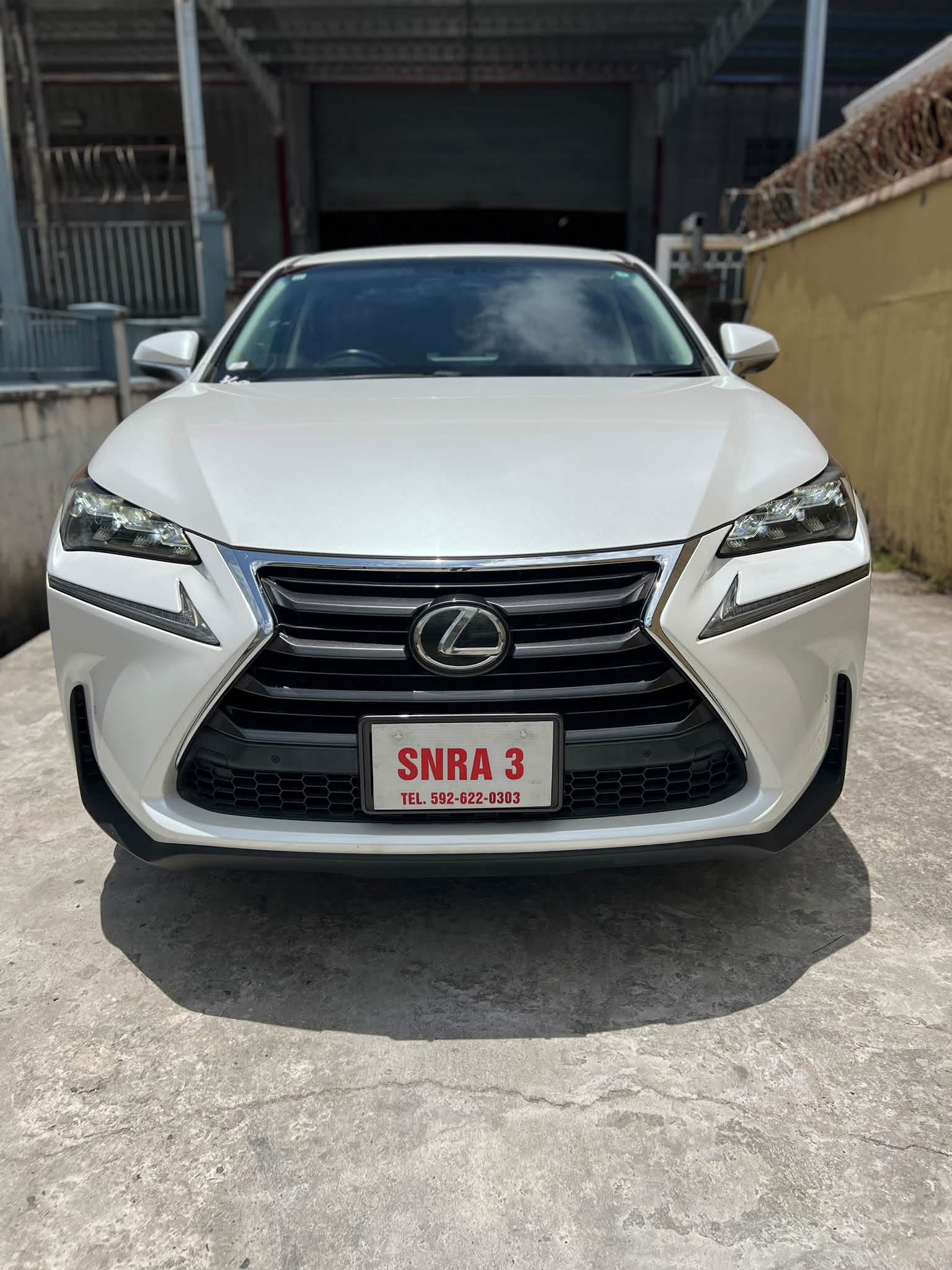 2015 Lexus NX200T Pearl White — straight-on front view showing bold spindle grille and LED headlights
