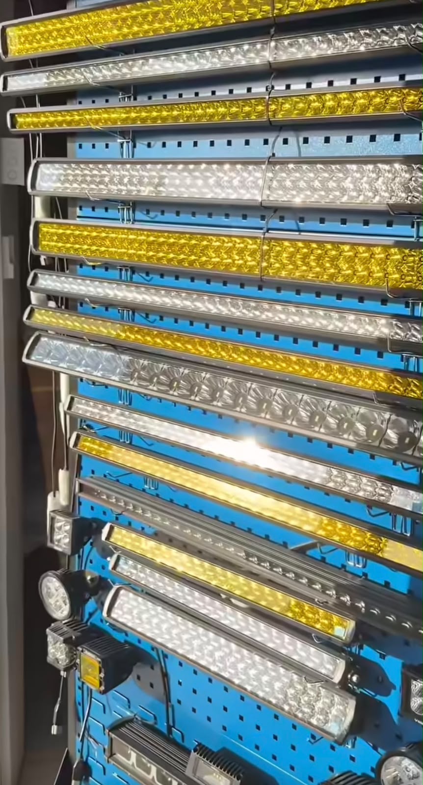 Display rack of LED light bars in white and amber at L.Singh Mechanic Shop, showing the range of driving lights available