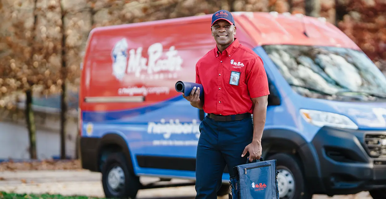 Mr. Rooter technician with branded service vans