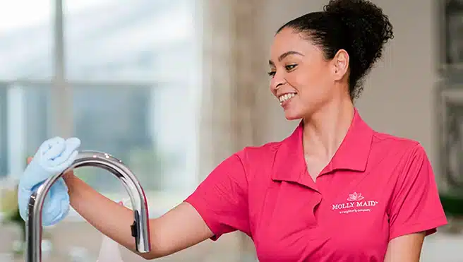 Molly Maid professional cleaning a kitchen faucet