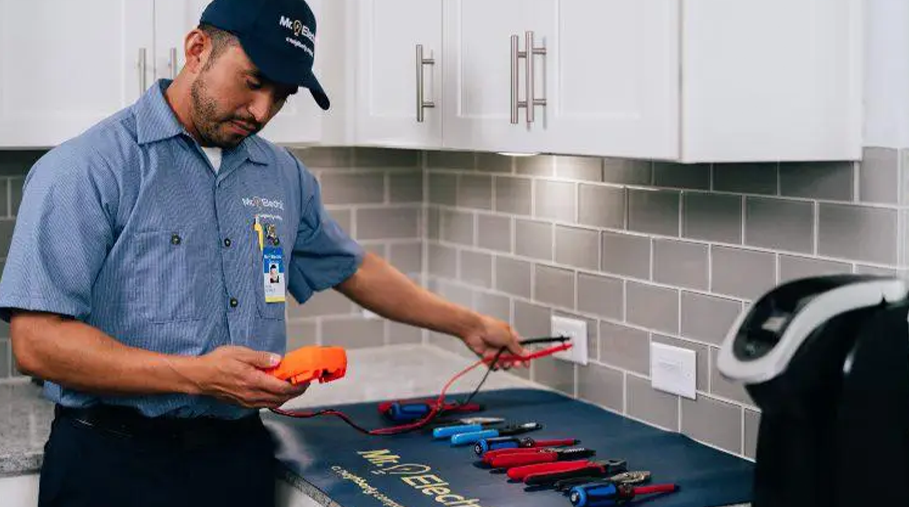 Mr. Electric technician testing an electrical outlet with professional tools in a kitchen
