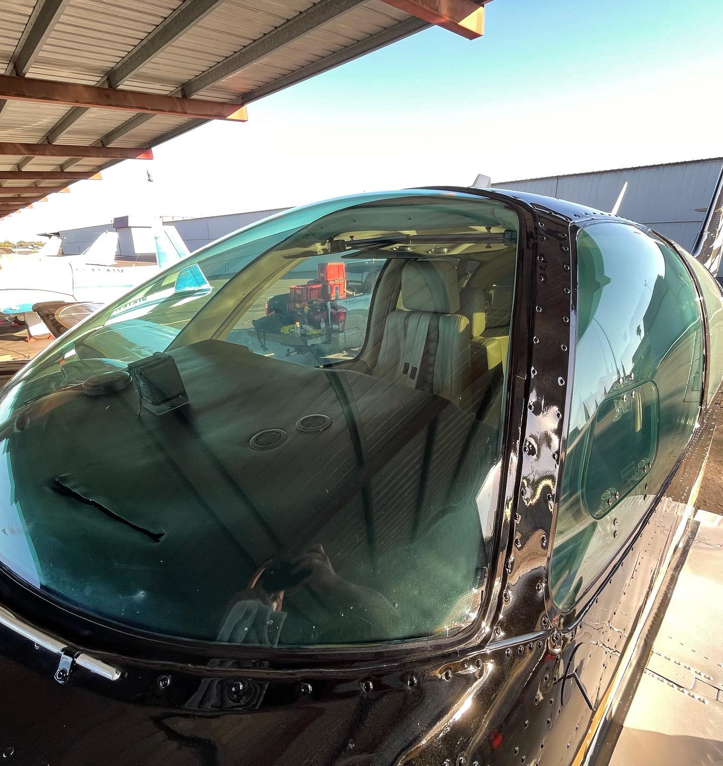 Private jet cockpit canopy detail showing polished aircraft surfaces
