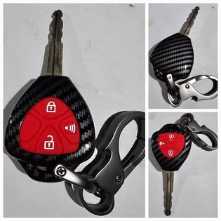 Car key fob with red button and black carbon fiber design